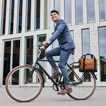Mann im Anzug fährt mit Fahrradtasche zur Arbeit – HOLE-X Fahrradtasche am Gepäckträger