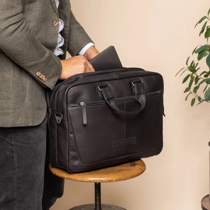 Laptoptasche Seth Schwarz – Mann öffnet Tasche auf Tisch | The Chesterfield Brand