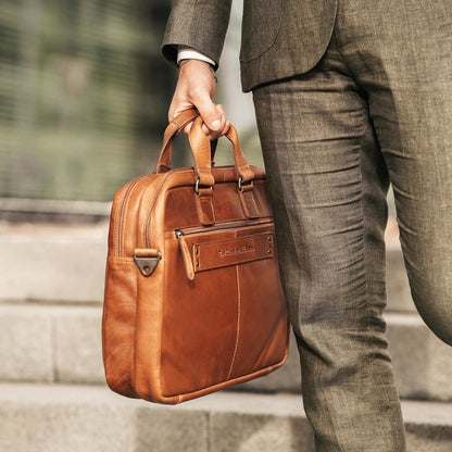 Laptoptasche Seth Cognac – Mann trägt Tasche am Griff im Business-Look | The Chesterfield Brand