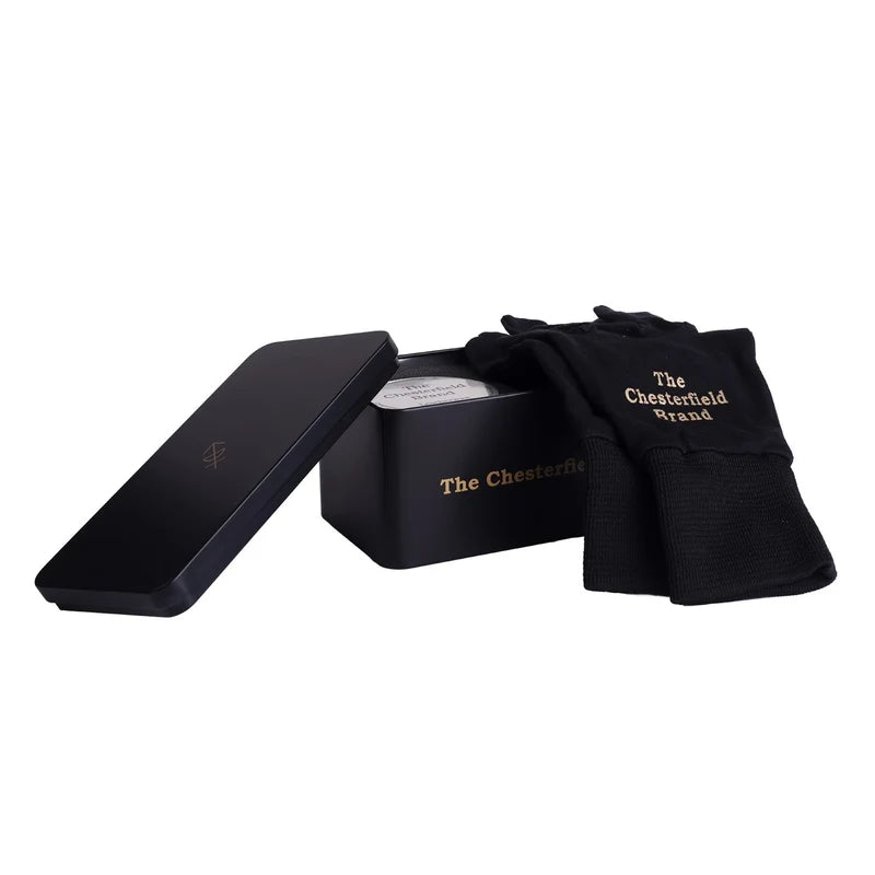 The Chesterfield Brand Pflegeset – geöffnete Box mit Lederwachs und schwarzen Handschuhen mit Logo-Stickerei